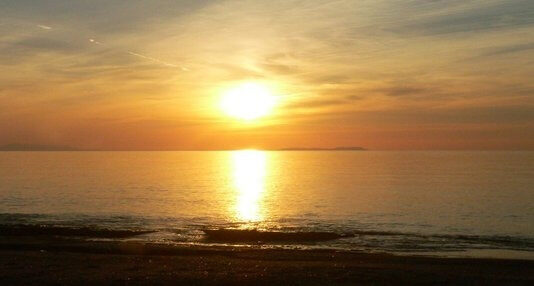 The sun setting over the sea at Acharavi beach