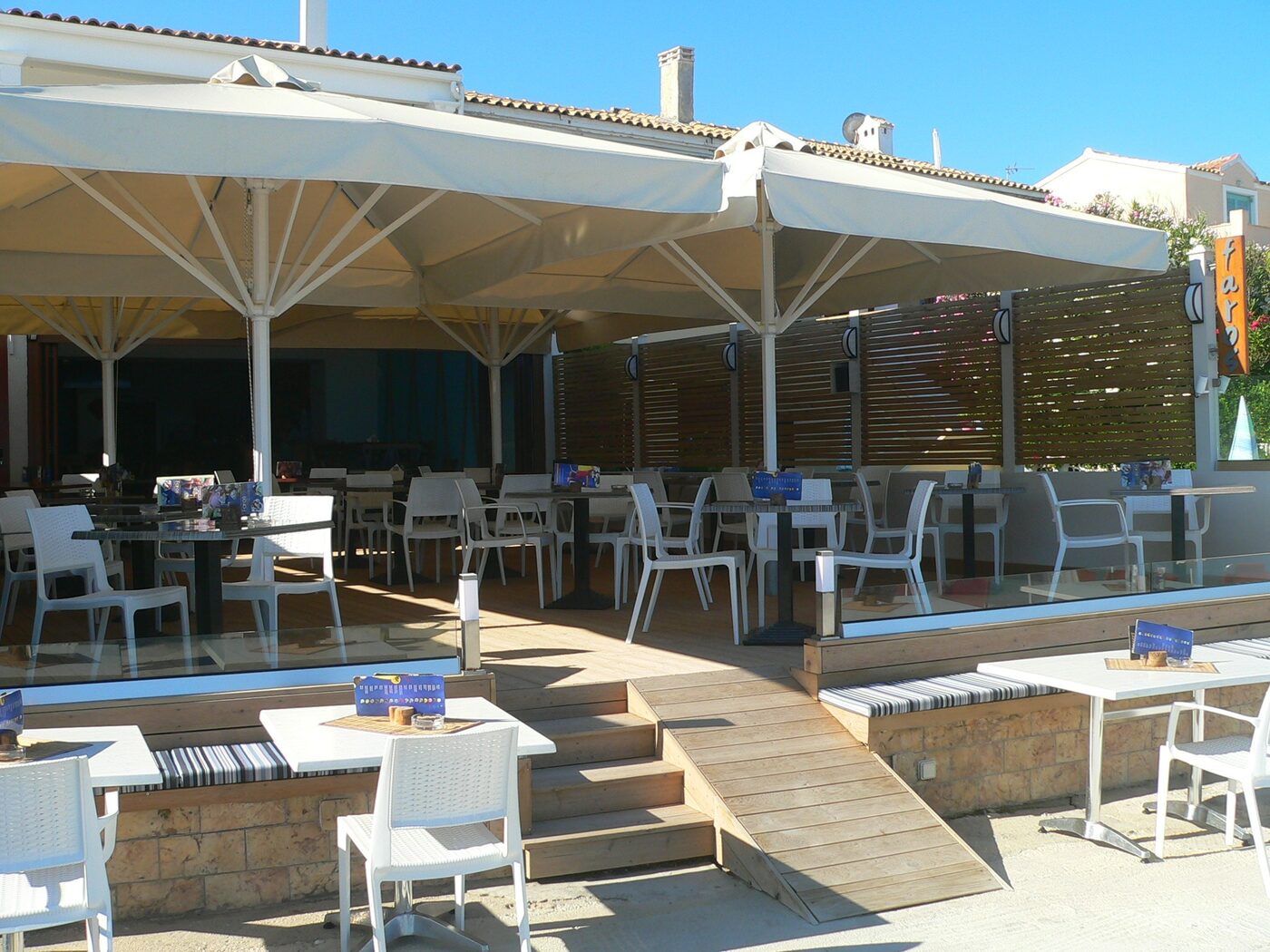 The terrace at Faros with white chairs set for lunch